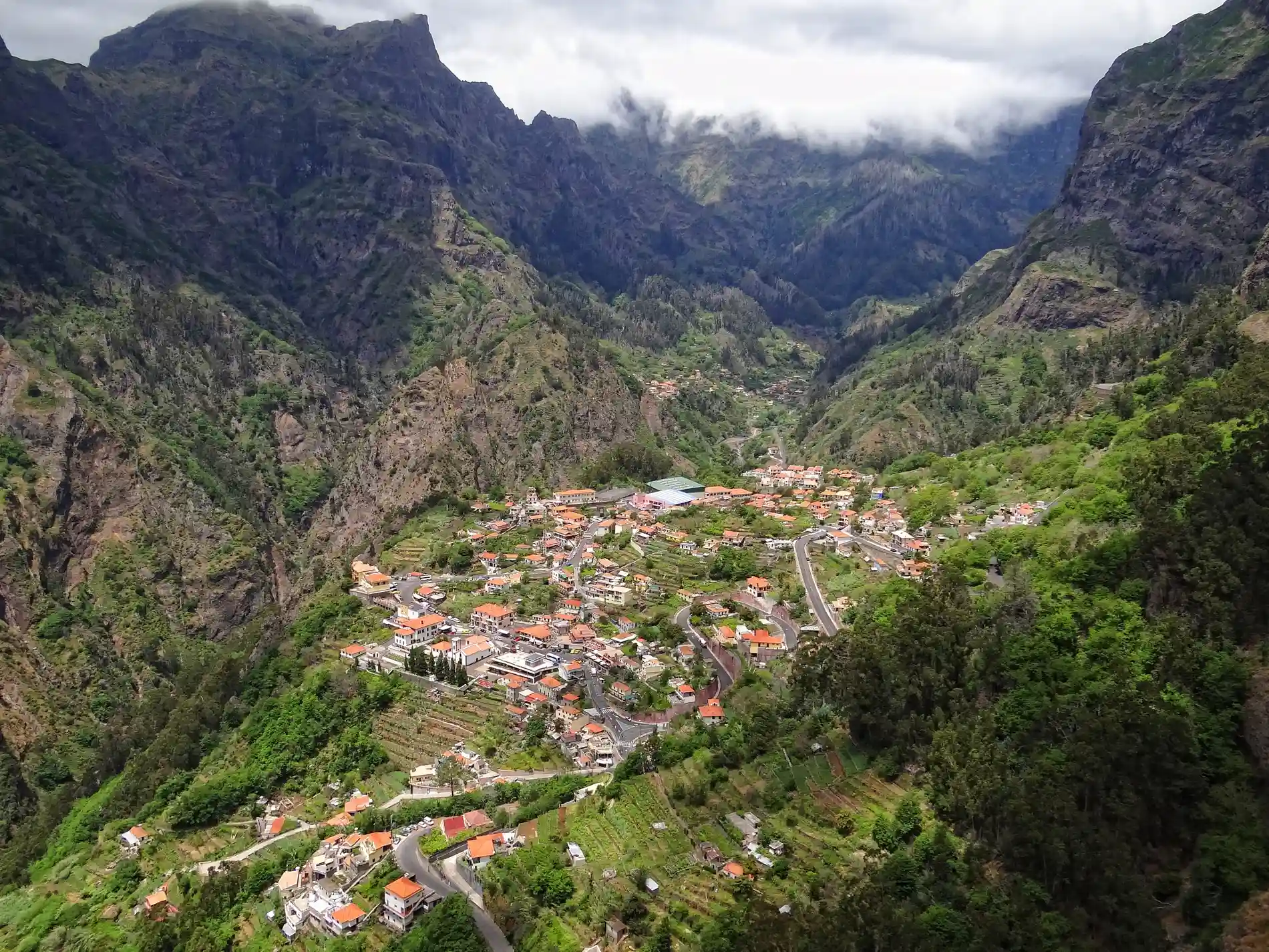 Aerial view of a village nestled in a lush mountain valley.