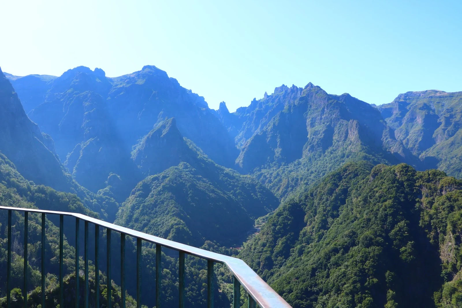 Mountain view with a railing in the foreground.