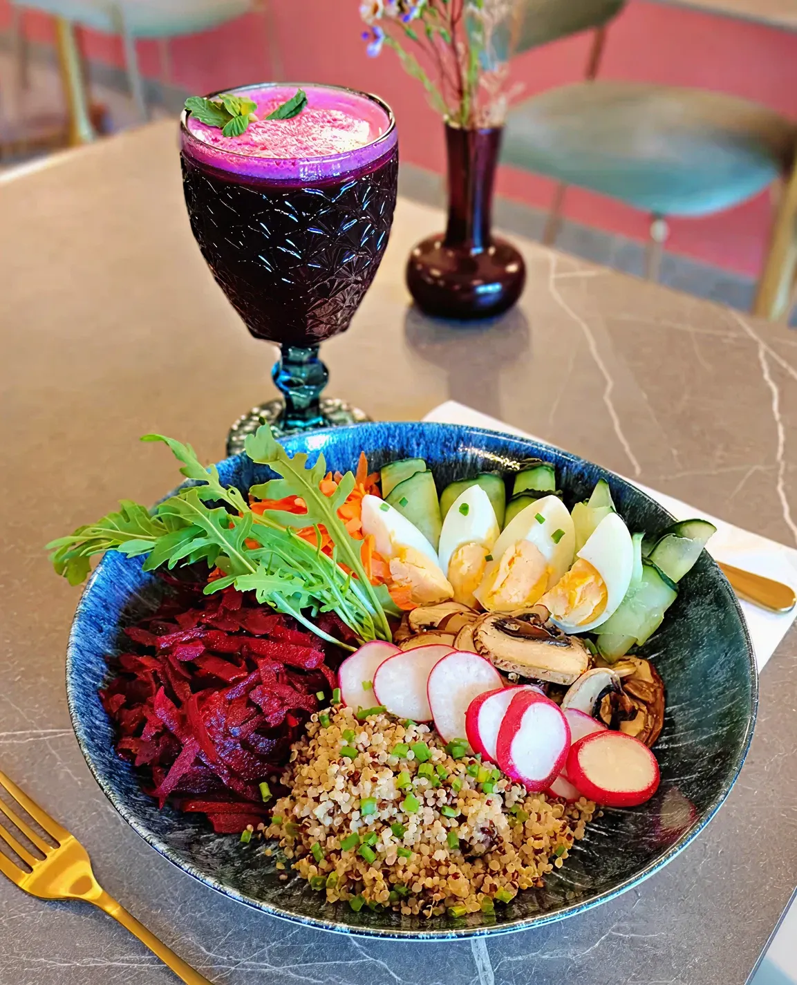 Colorful salad bowl with a vibrant purple drink.