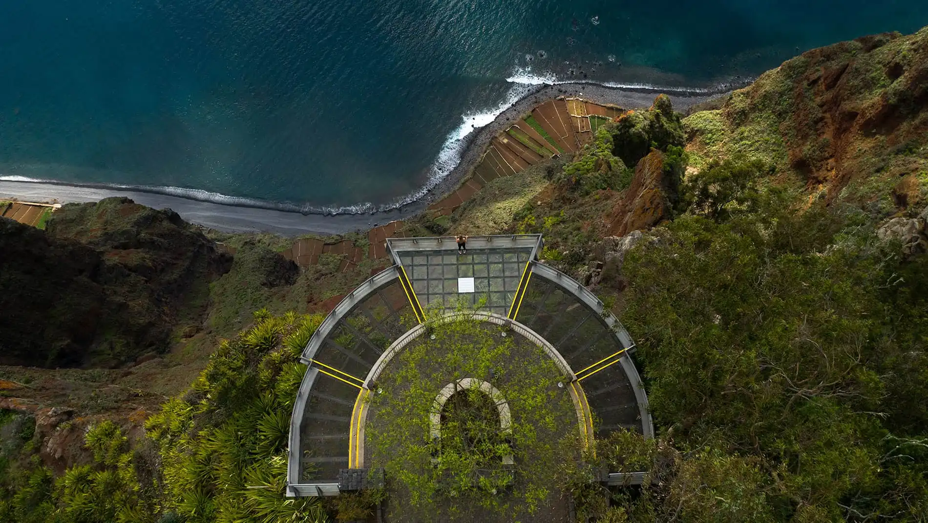 Aerial view of a glass platform overlooking the coastline and ocean.