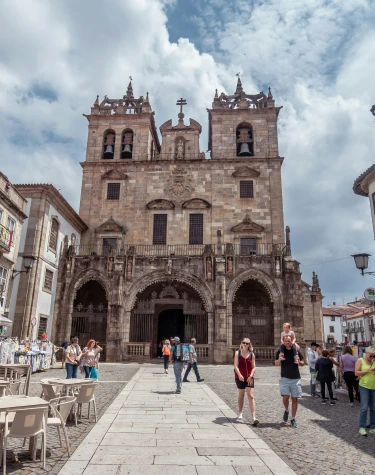 Catedral hist&oacute;rica em estilo g&oacute;tico com pessoas caminhando em frente.