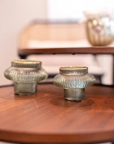 Dois casti&ccedil;ais de vidro em mesa de madeira.