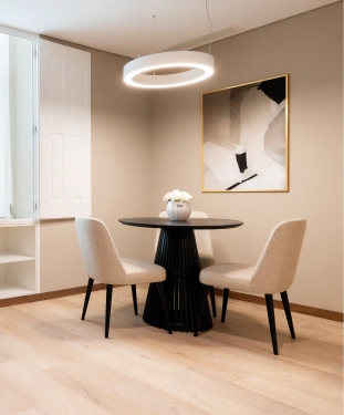 Sala de jantar moderna com mesa redonda, tr&ecirc;s cadeiras e quadro abstrato.