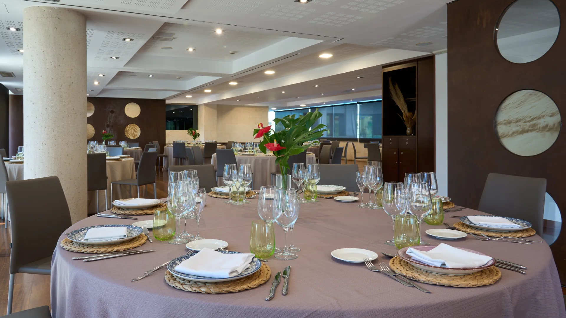 Mesa elegante en restaurante amplio con decoraci&oacute;n moderna y luces suaves.