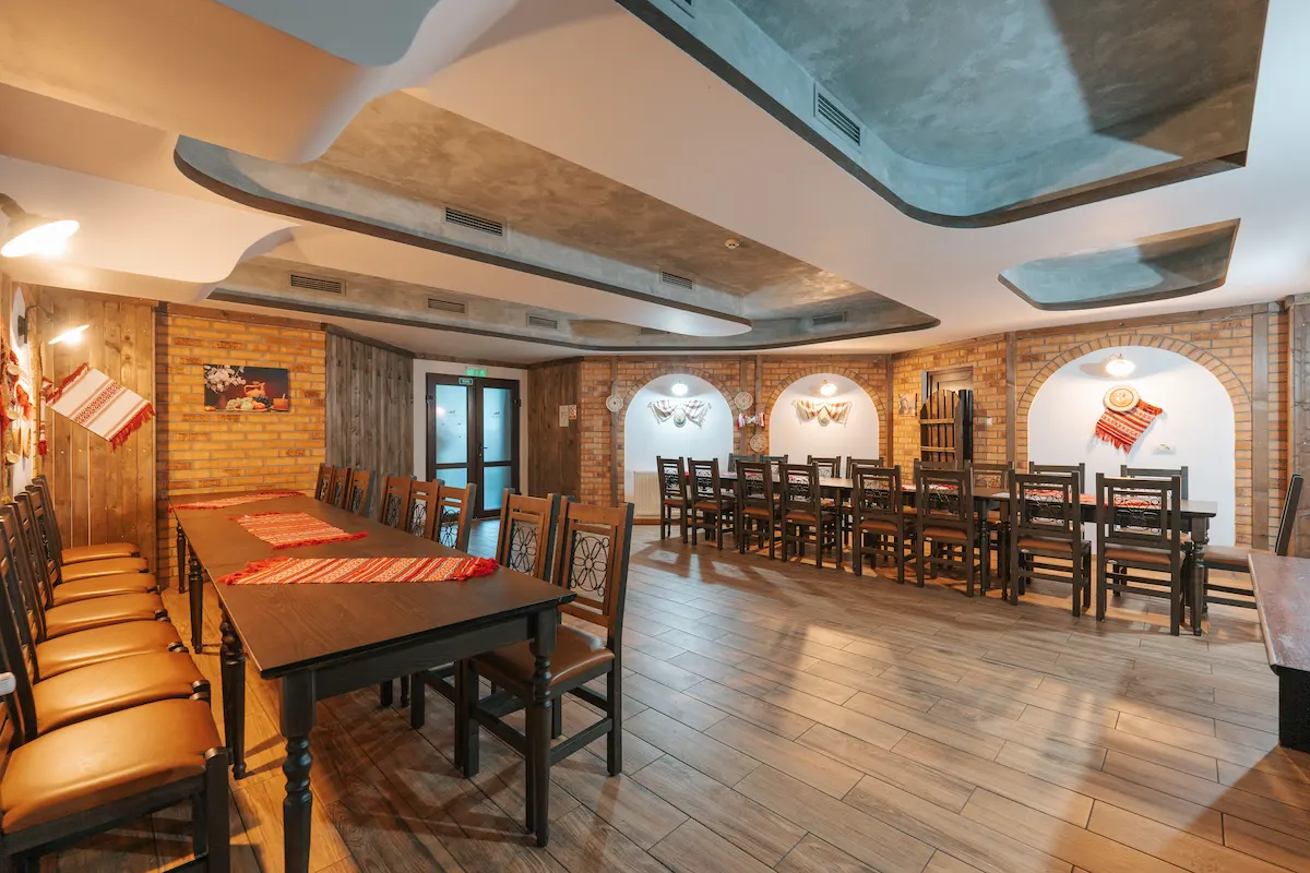 Wooden dining room with long tables and decorative brick walls.