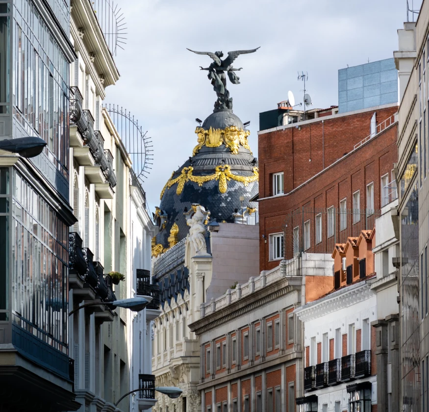 Calle con edificios y c&uacute;pula decorada en una ciudad.