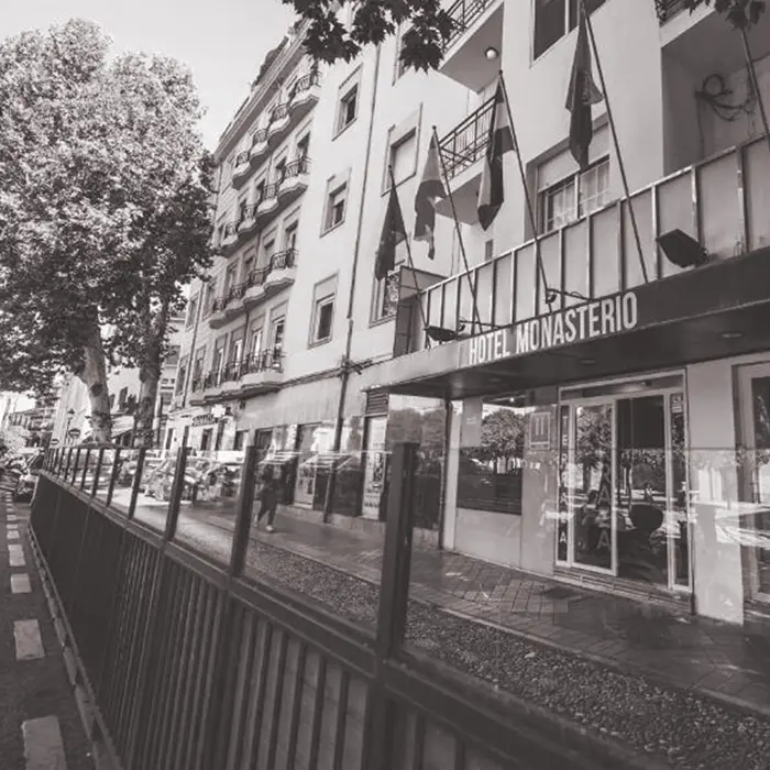 Fachada del Hotel Monasterio con banderas, vista desde la calle.