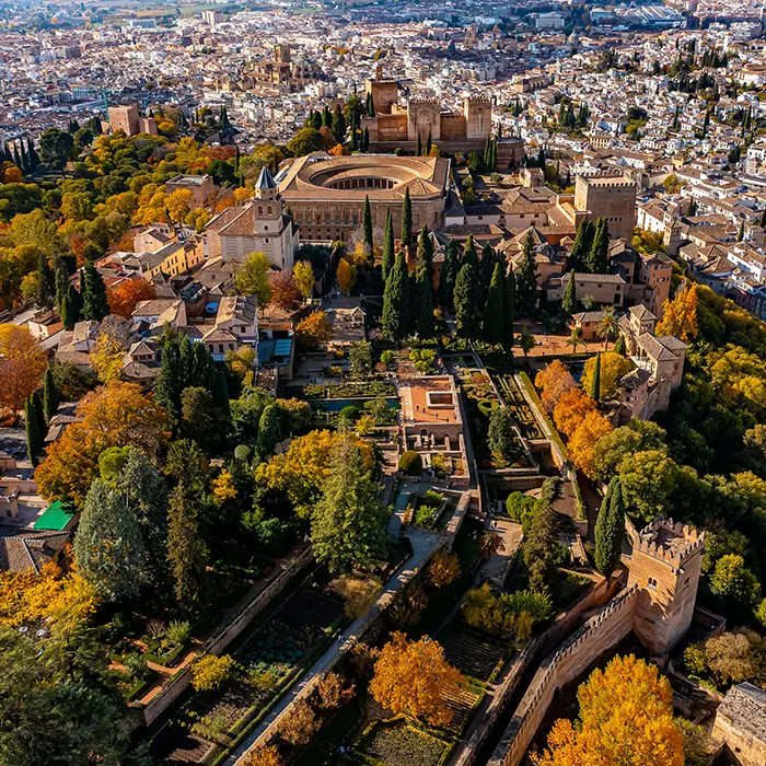 Vista a&eacute;rea de un conjunto de edificios hist&oacute;ricos y jardines en una ciudad.
