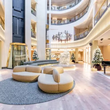 Lobby moderno y elegante con sof&aacute;s, piano y decoraciones navide&ntilde;as.