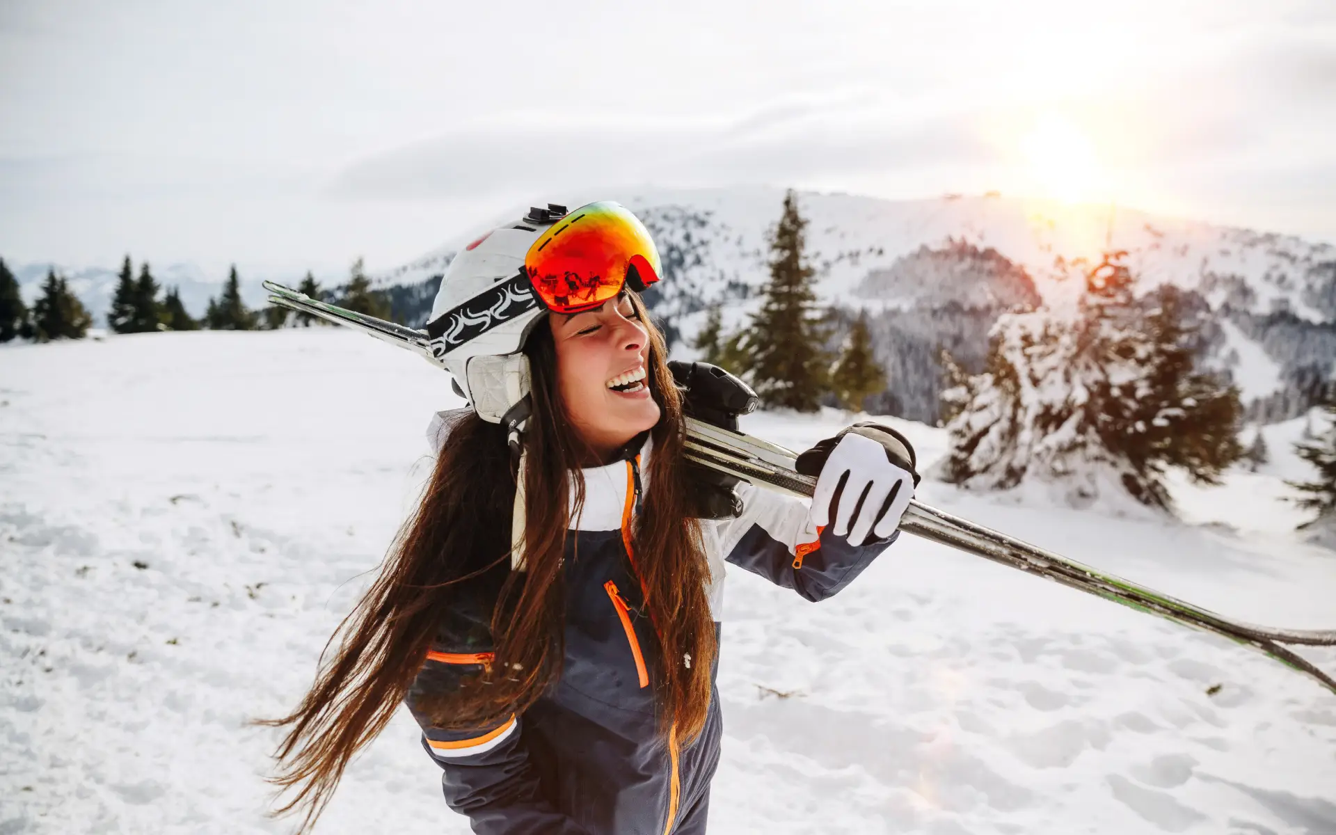 Persona sonriente con esqu&iacute;s en la nieve y paisaje monta&ntilde;oso.