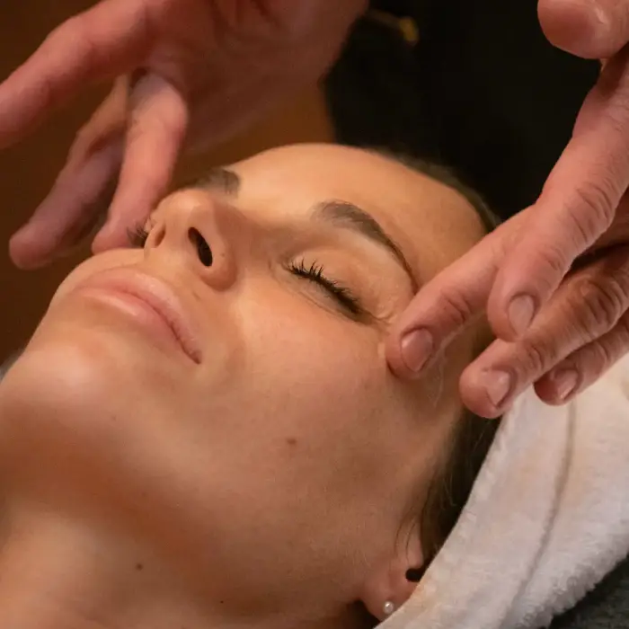 Persona recibiendo un masaje facial relajante en un spa.