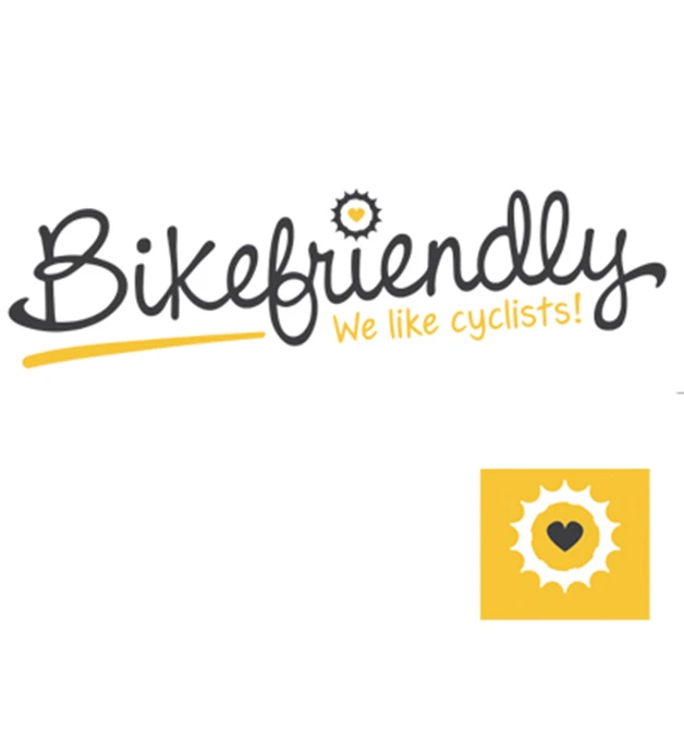 Logo de "Bikefriendly" y eslogan "We like cyclists" con un sol y coraz&oacute;n.