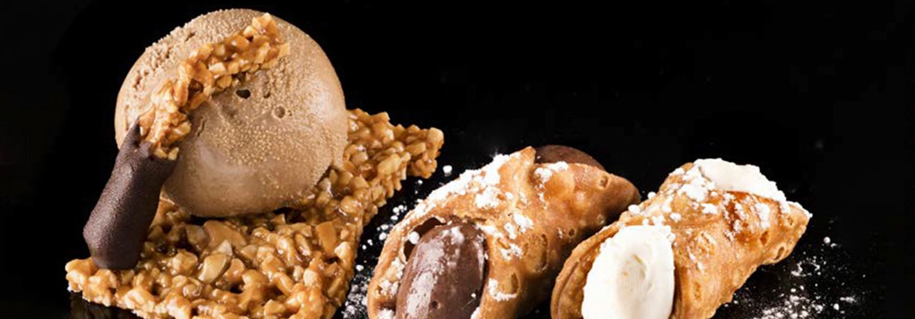 Helado con crocante y cannoli sobre fondo negro.