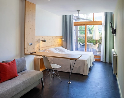 Habitaci&oacute;n moderna con cama, sof&aacute; y acceso al balc&oacute;n.