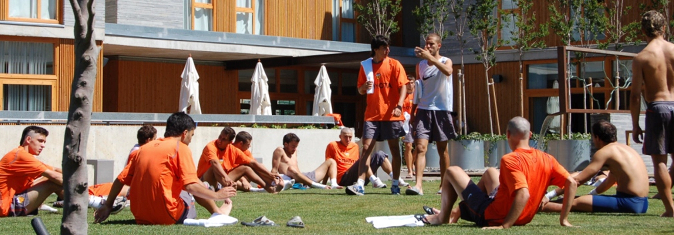 Grupo de hombres entrenando al aire libre en un jard&iacute;n.