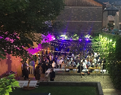 Fiesta al aire libre con luces coloridas y muchas personas reunidas.