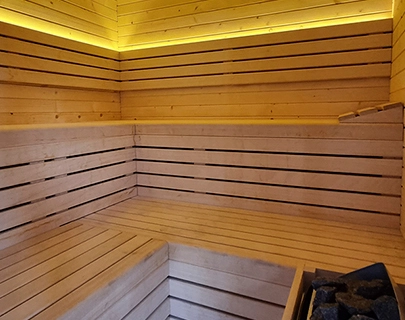 Sauna de madera iluminado con piedras para calentar.