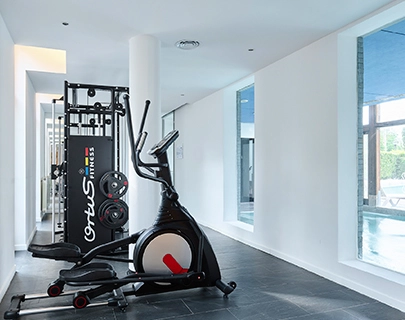 M&aacute;quinas de ejercicio en una sala de gimnasio moderna y luminosa.