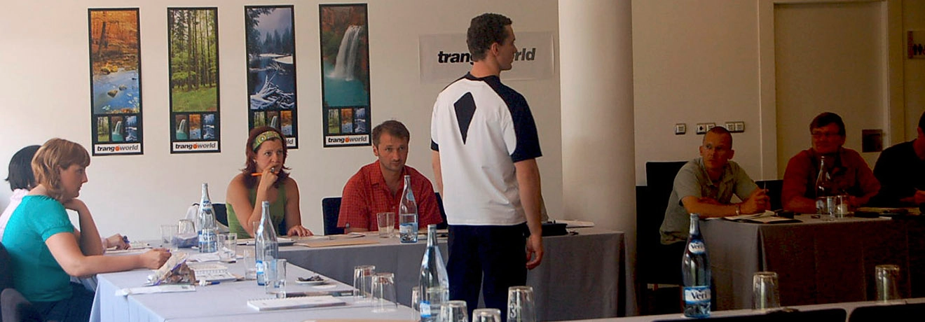Personas en una reuni&oacute;n sentadas alrededor de una mesa con botellas de agua.