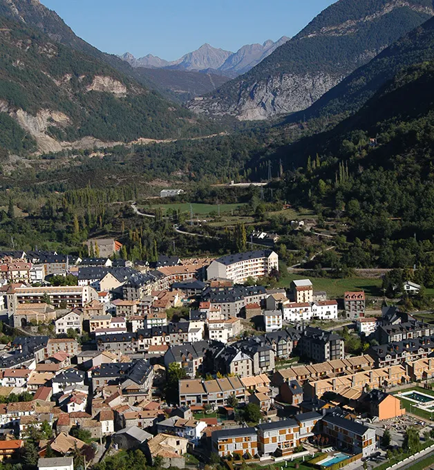 Pueblo en valle rodeado de monta&ntilde;as verdes.