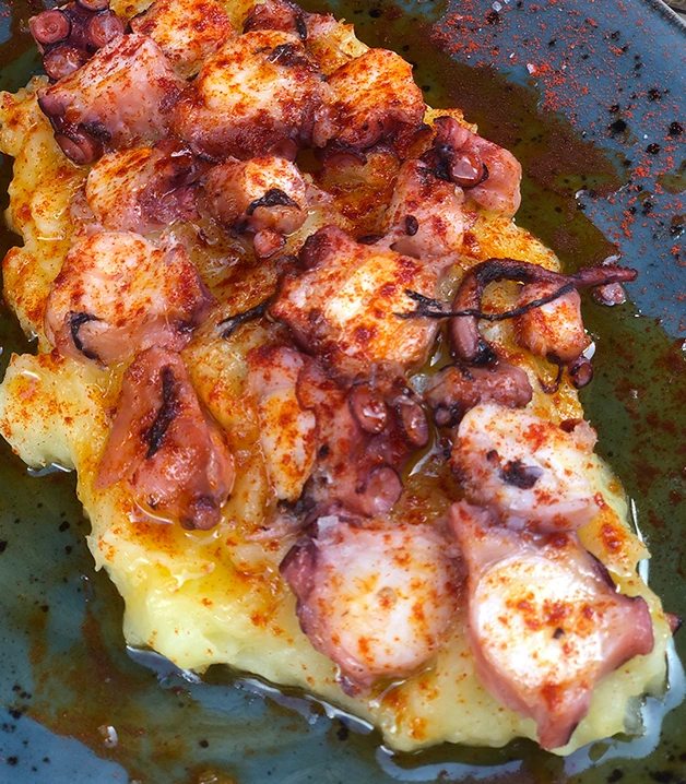 Pulpo a la gallega sobre pur&eacute;, espolvoreado con piment&oacute;n y aceite de oliva.