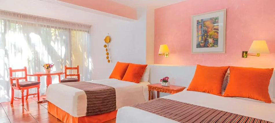 Habitaci&oacute;n con dos camas, paredes rosas y decoraci&oacute;n naranja.