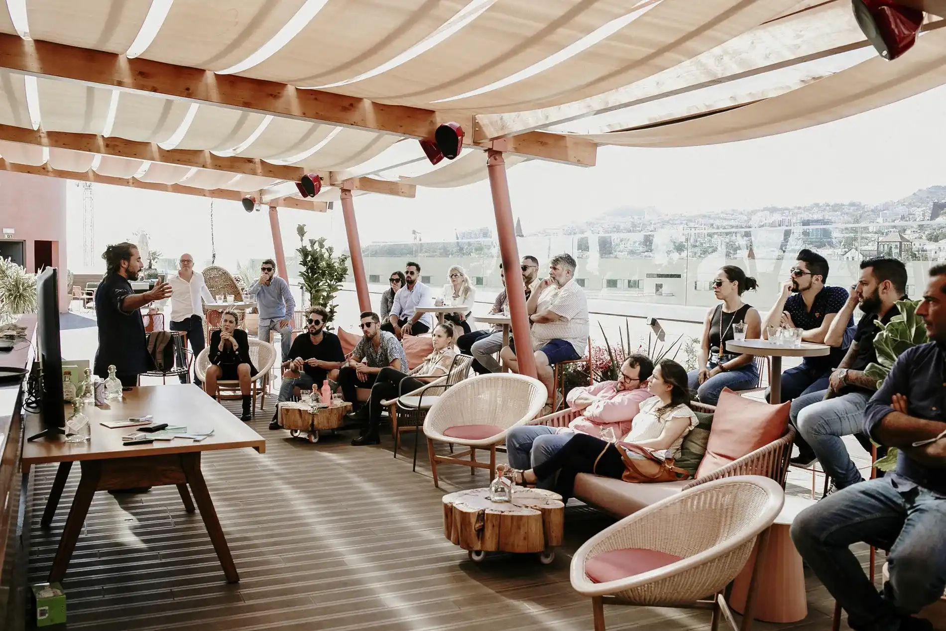 Pessoas participam de uma apresenta&ccedil;&atilde;o em um terra&ccedil;o coberto ao ar livre.