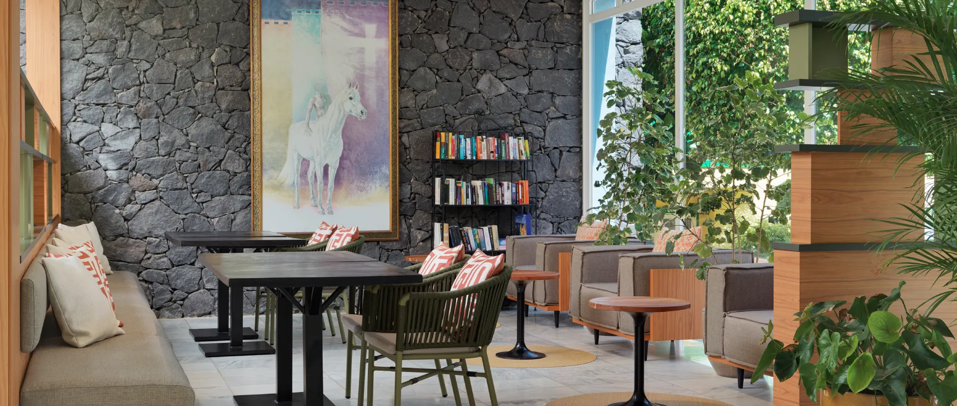 Sala moderna con cuadros, libros y plantas, sof&aacute; gris y cojines decorativos.