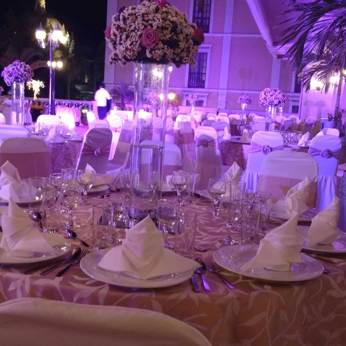 Mesa de banquete decorada con flores y servilletas elegantes por la noche.