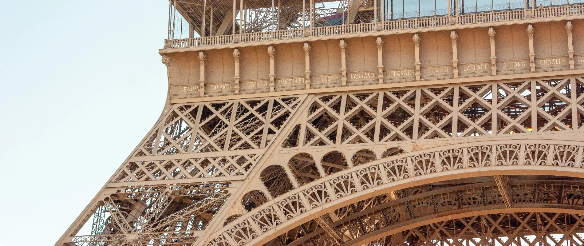 D&eacute;tail de la structure m&eacute;tallique de la tour Eiffel avec des noms grav&eacute;s.