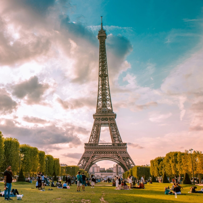 Tour Eiffel avec des visiteurs assis dans le parc par une journ&eacute;e ensoleill&eacute;e.