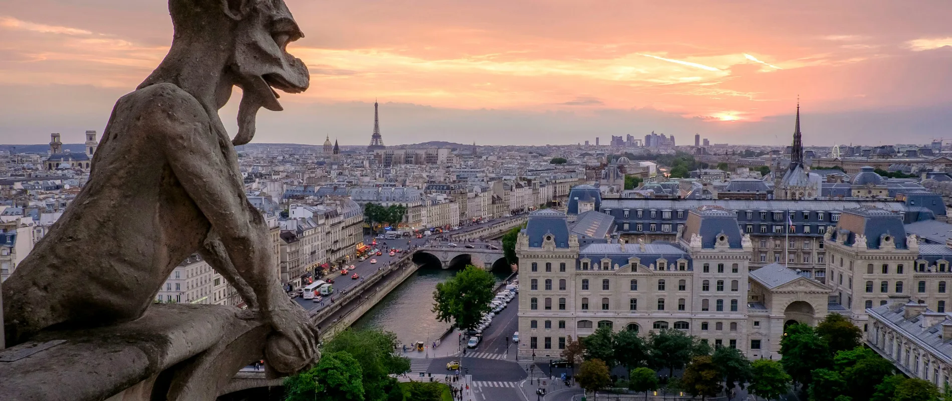 Vue de Paris depuis Notre-Dame au cr&eacute;puscule, avec une gargouille au premier plan.