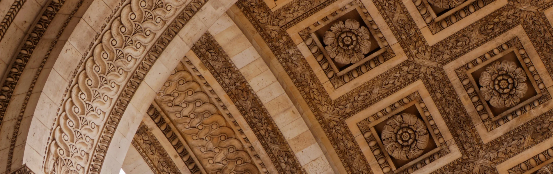 Plafond en pierre sculpt&eacute;e avec motifs floraux et g&eacute;om&eacute;triques.