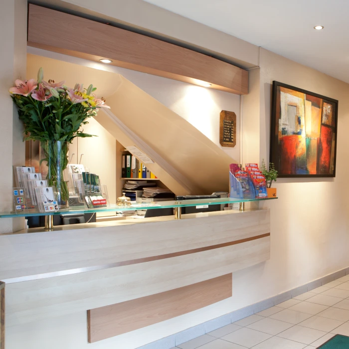 Comptoir de r&eacute;ception moderne avec fleurs et brochures.