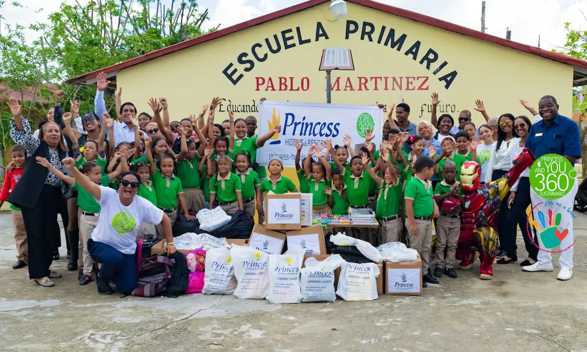 Foto grupal con ni&ntilde;os, adultos y letrero &ldquo;Escuela Primaria Pablo Mart&iacute;nez&rdquo; y marca Princess.