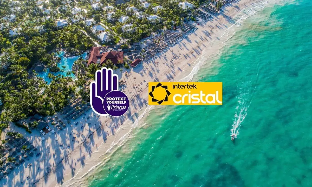 Playa a&eacute;rea con logos Protect Yourself y Intertek Cristal sobre el mar turquesa.