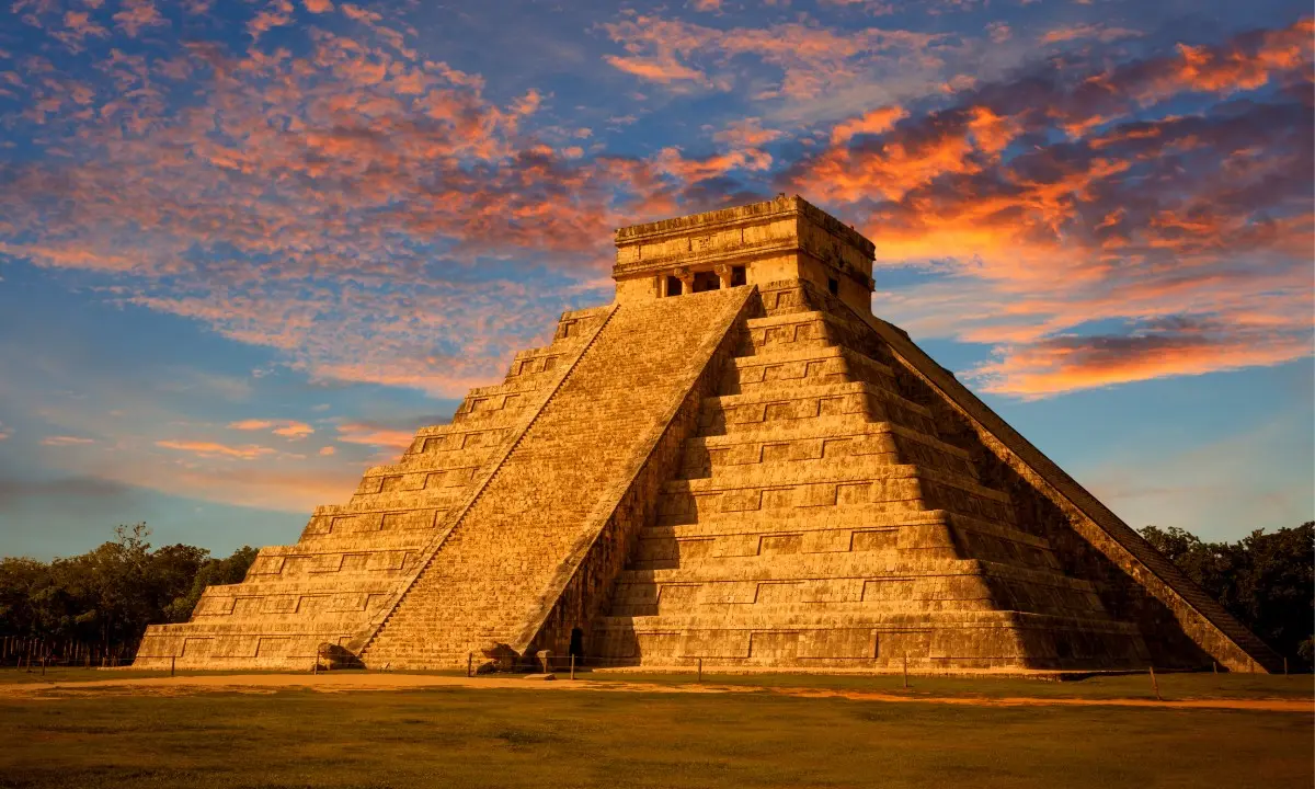 Pir&aacute;mide de Kukulc&aacute;n en Chich&eacute;n Itz&aacute; al atardecer, cielo nublado y anaranjado