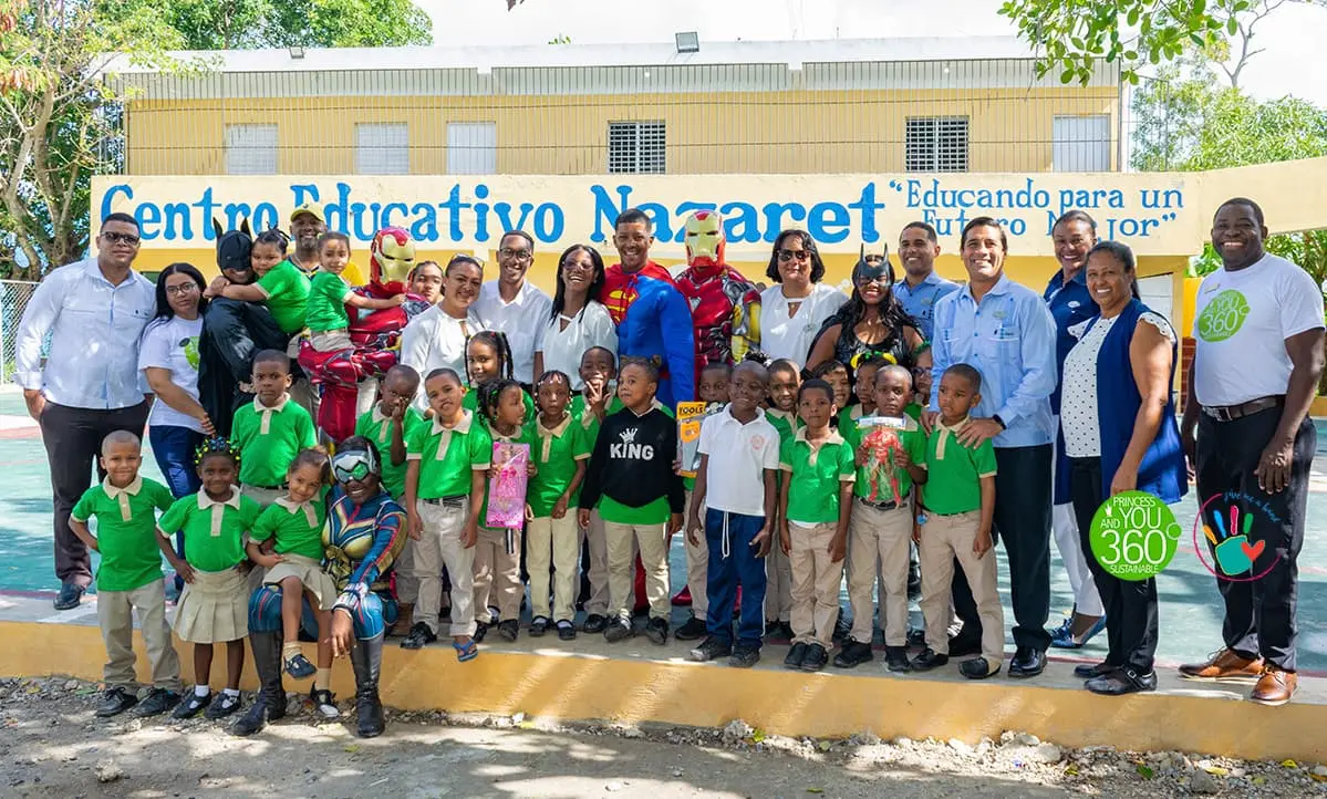 Foto grupal en Centro Educativo Nacaret con ni&ntilde;os y personal frente al mural.