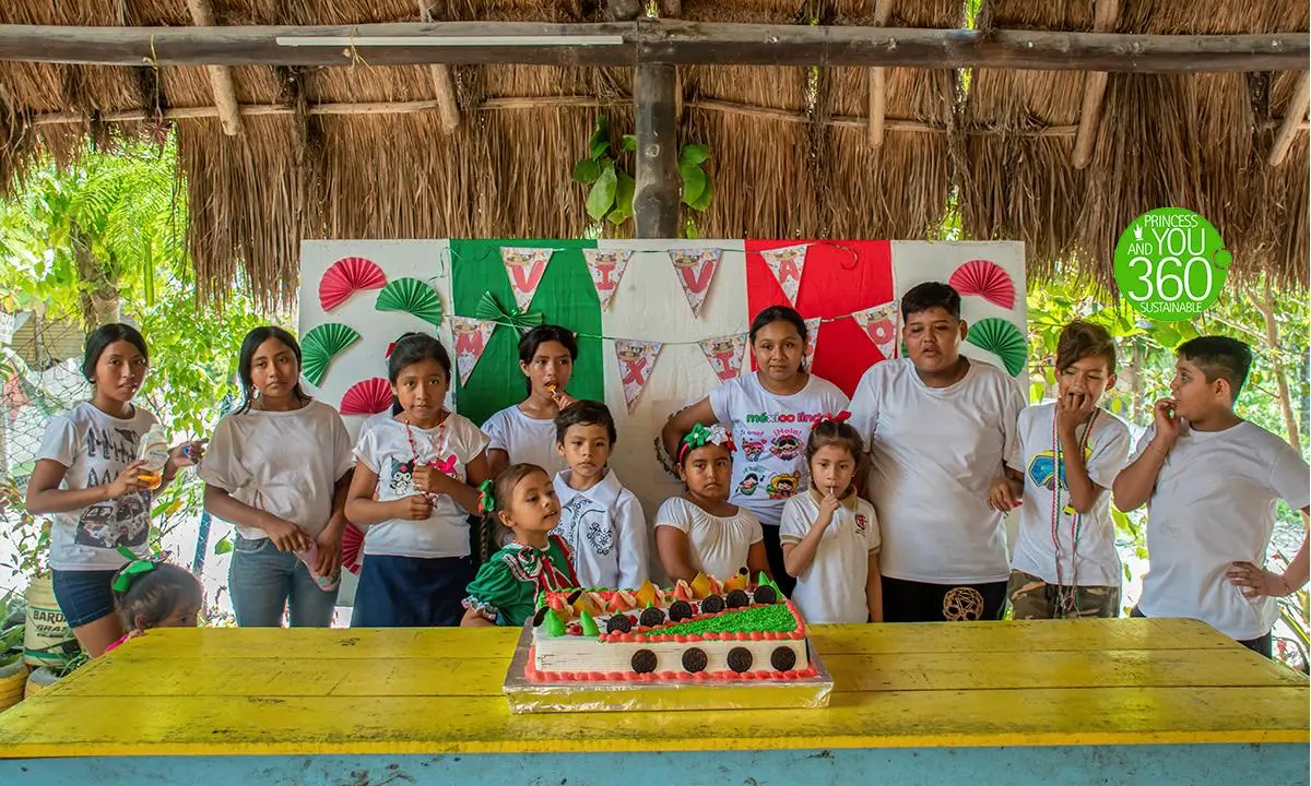 Familia con camisetas, celebrando cumplea&ntilde;os frente a una mesa con pastel y pi&ntilde;ata.