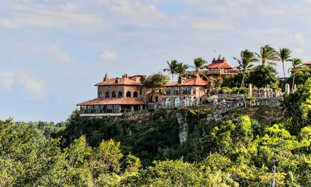 Casas coloniales y palmeras sobre una colina con vegetaci&oacute;n tropical al fondo