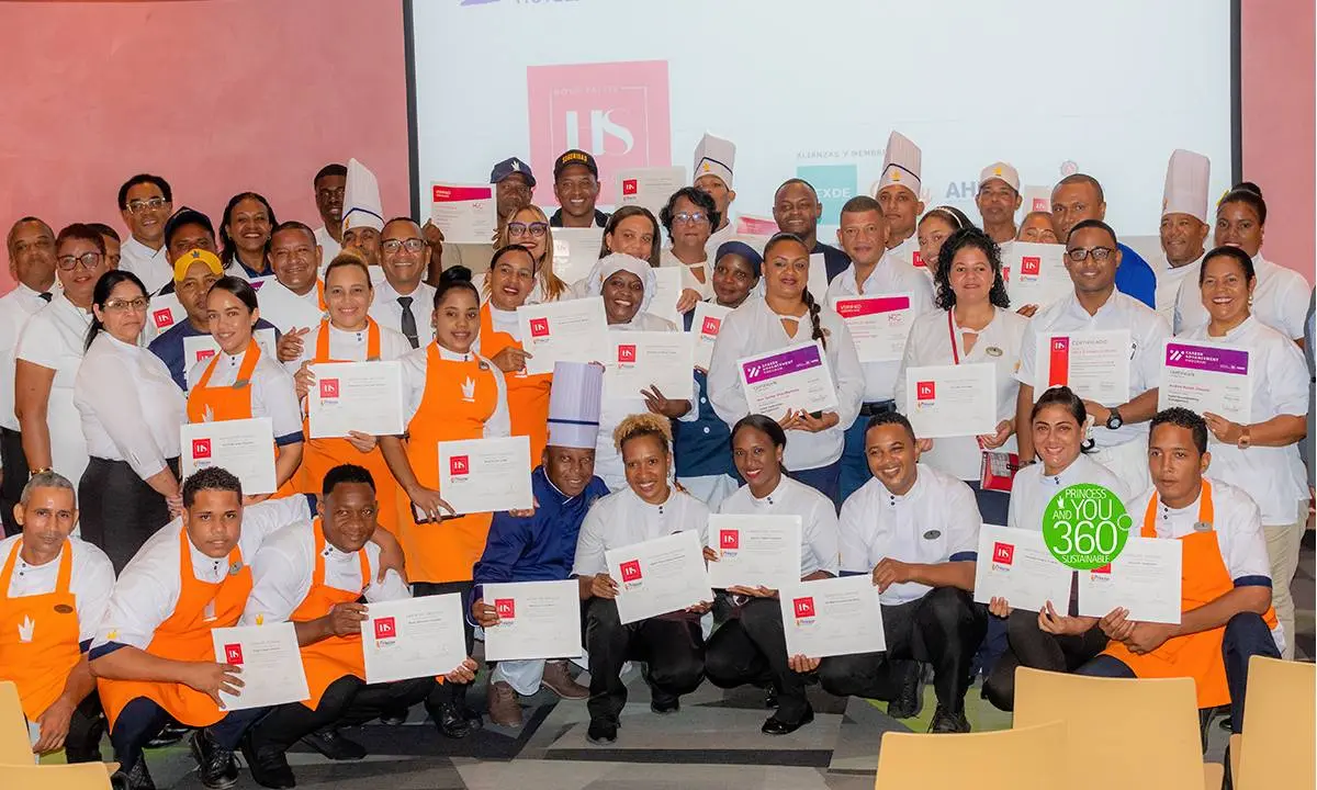 Grupo de chefs y personal con certificados, posando en un evento.