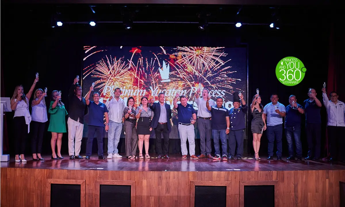 Foto grupal en escenario con fuegos artificiales y premios en evento corporativo