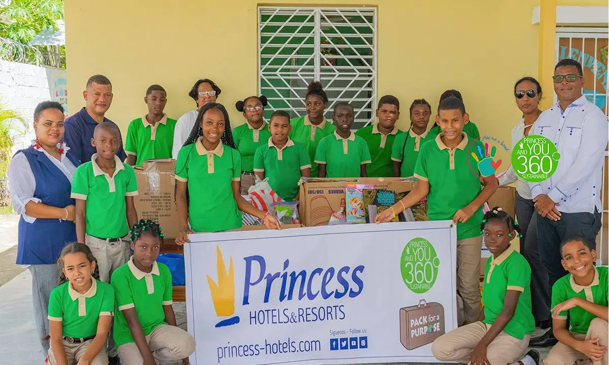 Grupo de ni&ntilde;os y adultos con el letrero &ldquo;Princess Hotels & Resorts&rdquo;