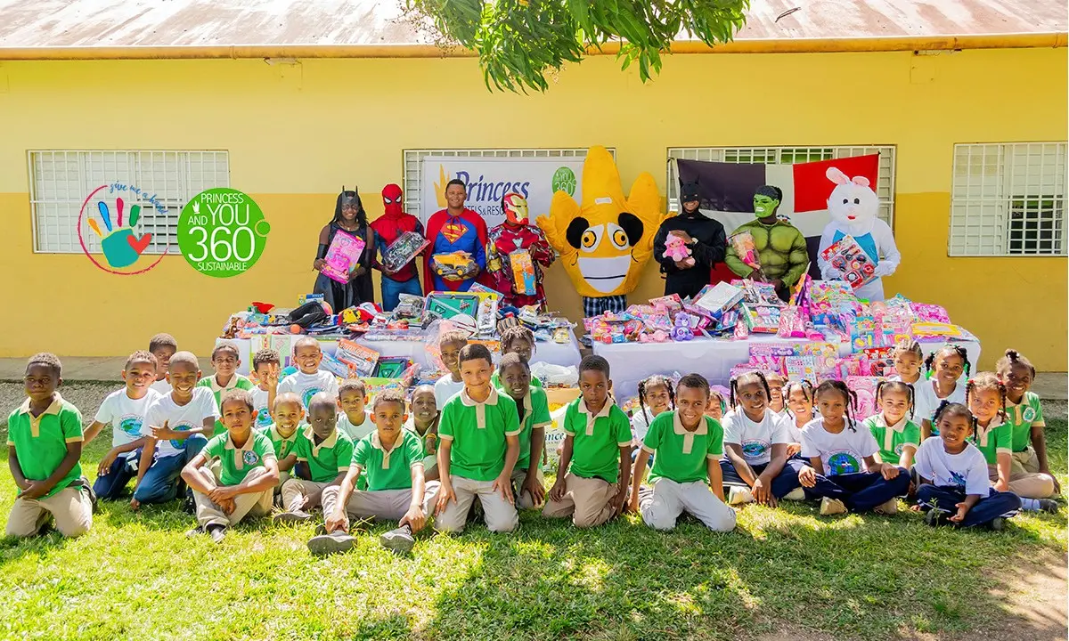 Grupo de ni&ntilde;os y disfraces frente a un muro amarillo con regalos y dulces