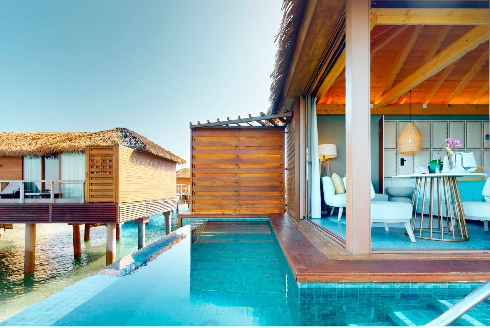 Piscina y caba&ntilde;as sobre el agua, con sala interior y luz de techo.