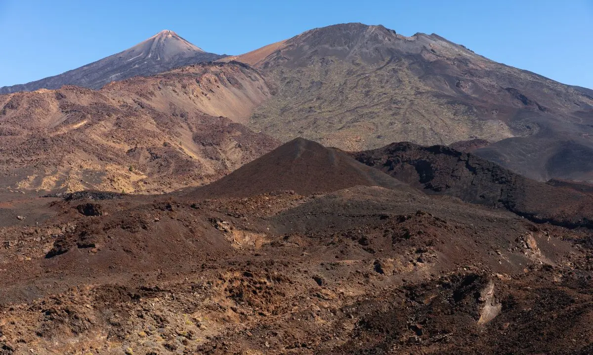 Der Teide erhebt sich im Hintergrund über einer Vulkanlandschaft aus Lavafeldern