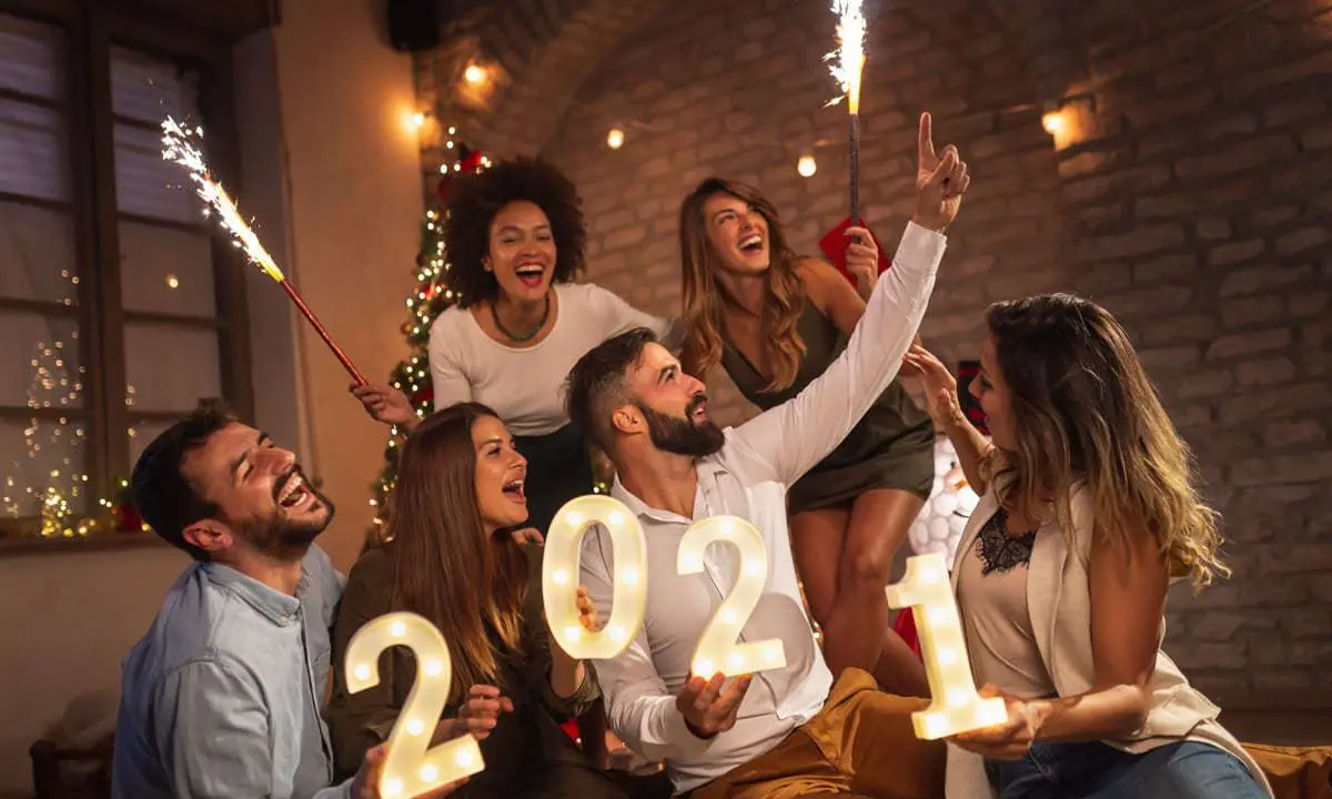 Grupo de amigos celebrando cumplea&ntilde;os, con velas &ldquo;2024&rdquo; y fiesta en casa