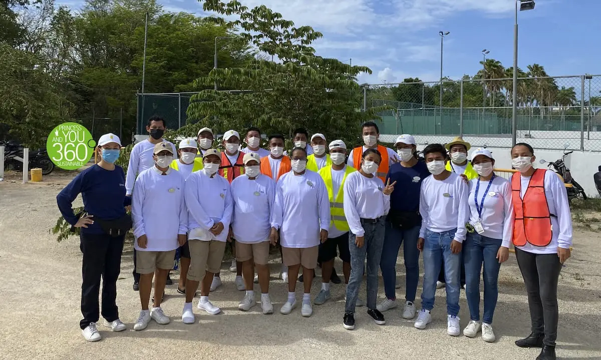 Foto de grupo con participantes con mascarillas en cancha deportiva al aire libre