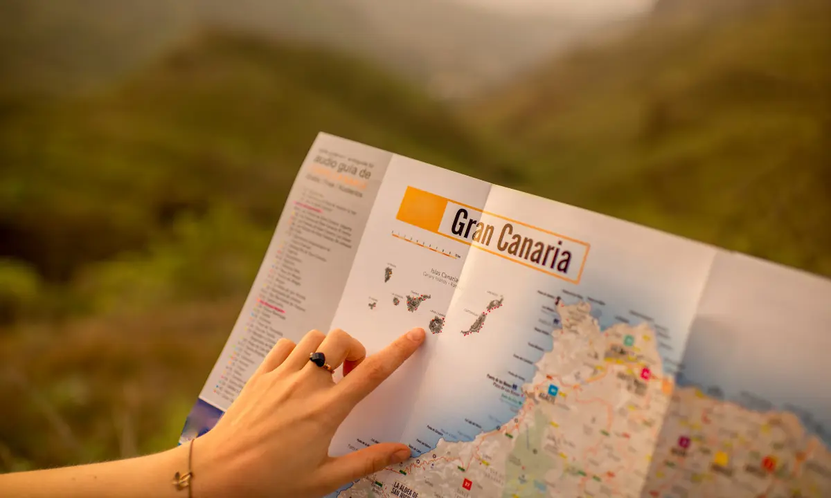 Mano se&ntilde;ala un mapa tur&iacute;stico del &ldquo;Gran Canaria&rdquo; al aire libre