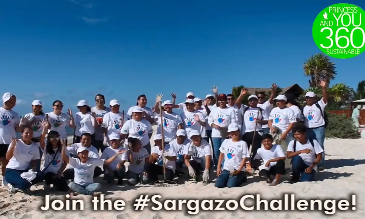 Grupo de personas en la playa con camisetas &ldquo;#SargazoChallenge&rdquo; y pancarta verde
